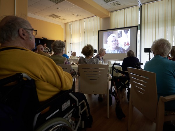 SeniorInnen schauen in einer Pflegeeinrichtung Filme.
